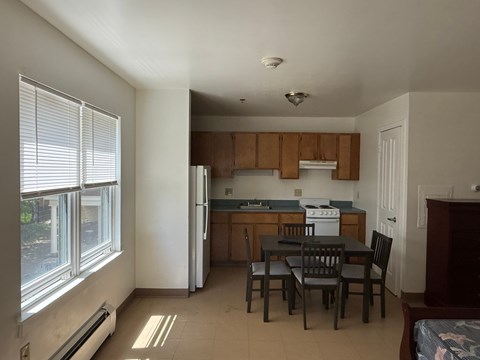 A kitchen with a table and chairs.