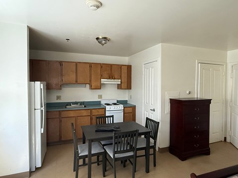 A kitchen with a table and chairs.
