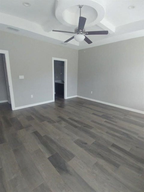 a living room with wood floors and a ceiling fan