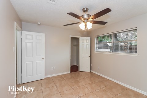 a living room with a ceiling fan and a door to a closet