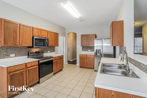 A kitchen with wooden cabinets and a stainless steel refrigerator.