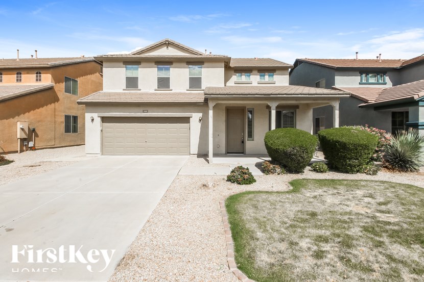 A house with a garage and a driveway in front of it.