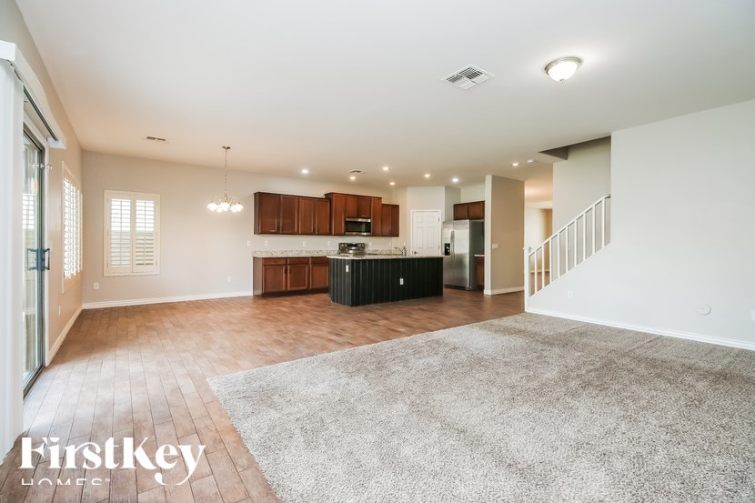 A spacious living room with a staircase leading to the upper floor.