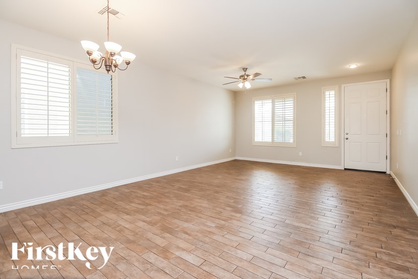 A room with wooden flooring and a chandelier hanging from the ceiling.