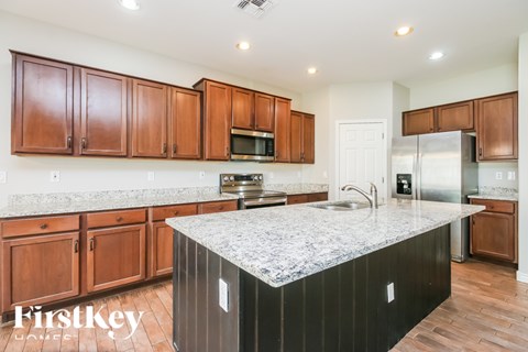 A kitchen with wooden cabinets and a marble countertop.