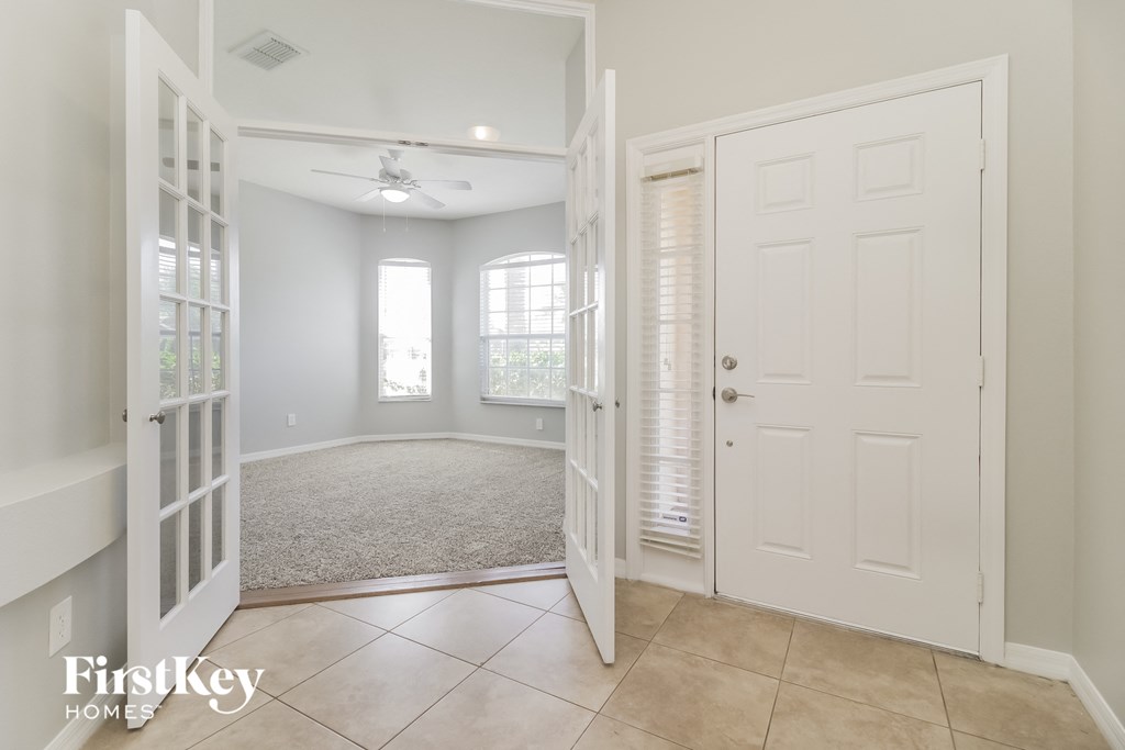 an empty room with a white door and a carpeted floor