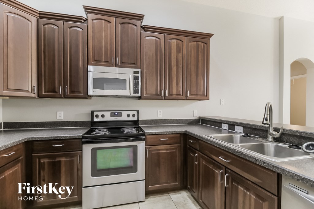a kitchen with wooden cabinets and stainless steel appliances