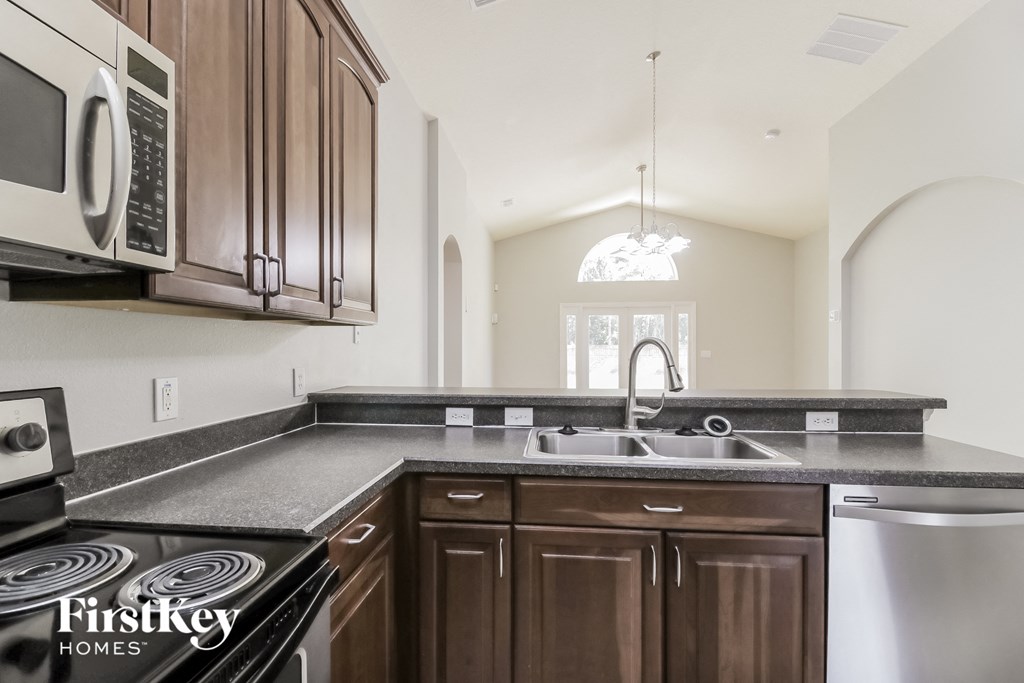 a kitchen with wooden cabinets and a sink and a microwave