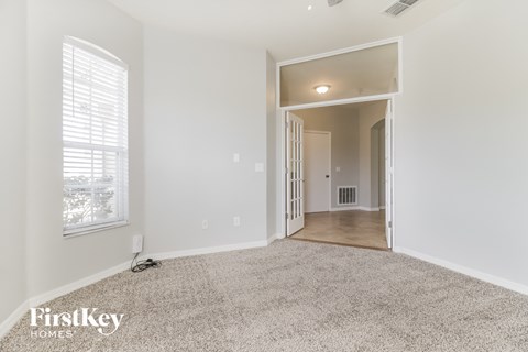 a spacious living room with carpet and a large window