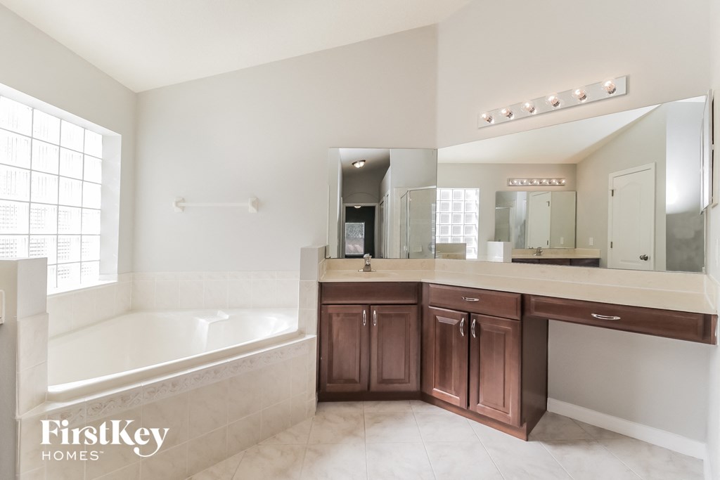 a bathroom with a tub and a sink and a mirror