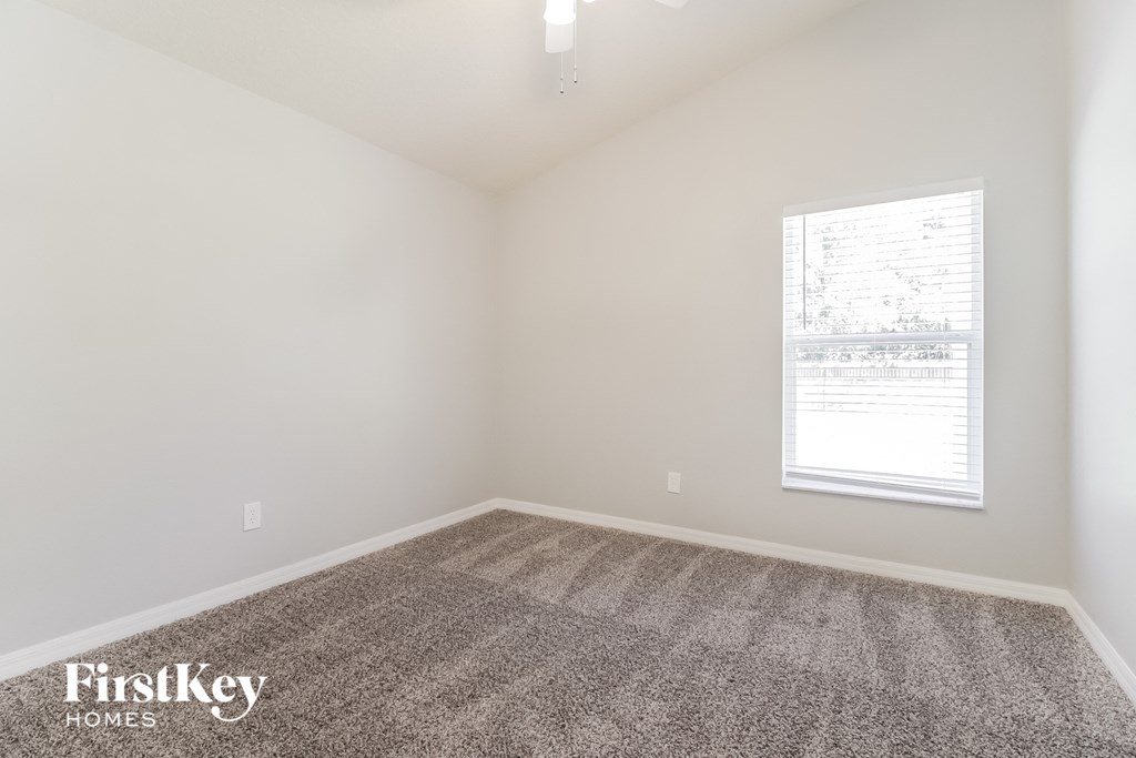 an empty room with carpet and a window