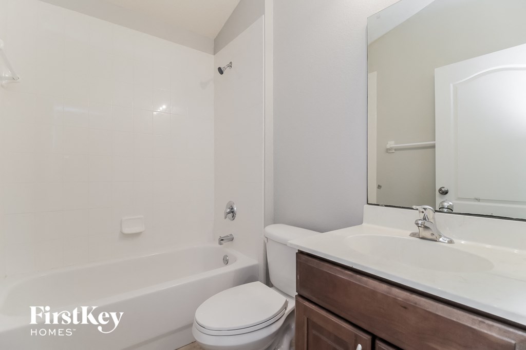 a bathroom with a toilet sink and tub and a mirror