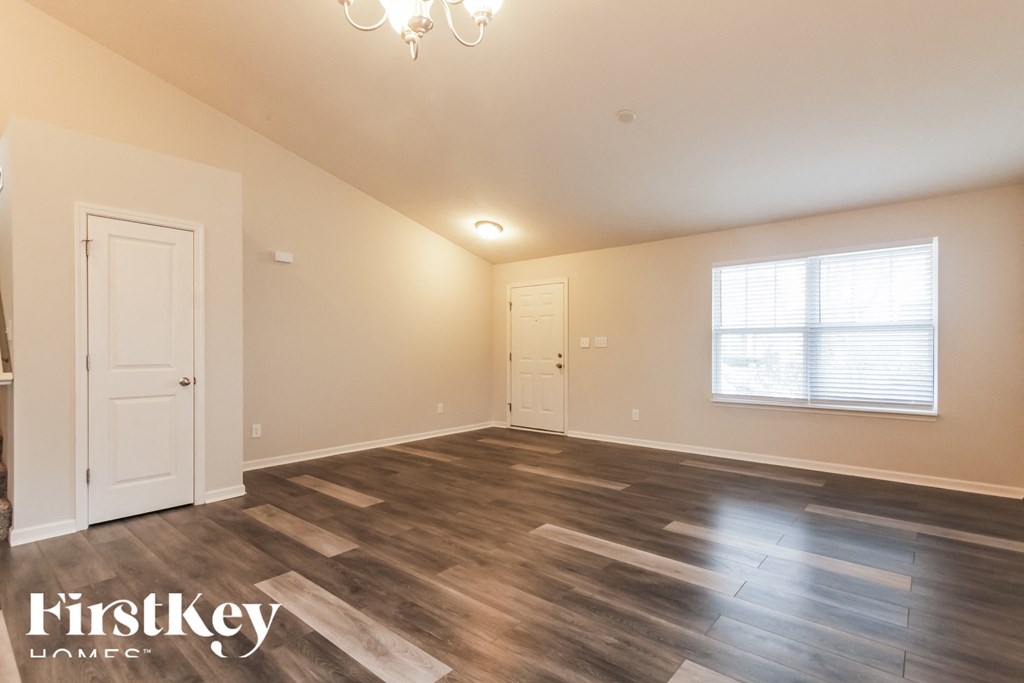 A room with wooden flooring and a chandelier.