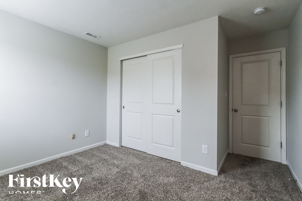 A room with two doors and a carpeted floor.