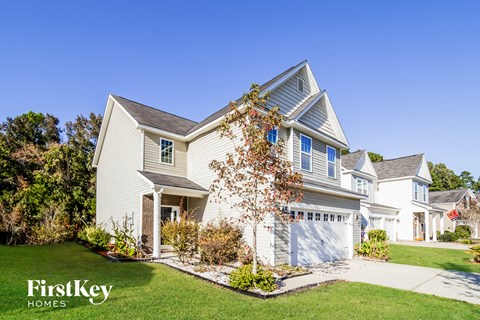 a white house with a white garage door and a lawn