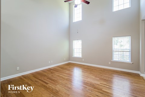 a living room with wood floors and a ceiling fan