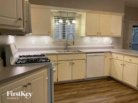 A kitchen with wooden cabinets and a stove top oven.