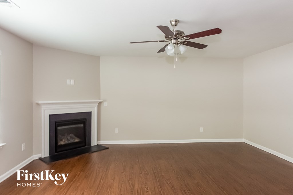a living room with a ceiling fan and a fireplace