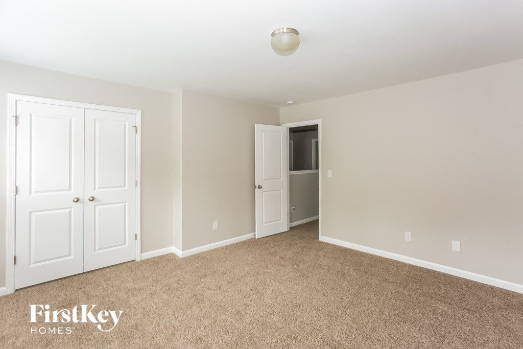 a master bedroom with two closets and a carpeted floor