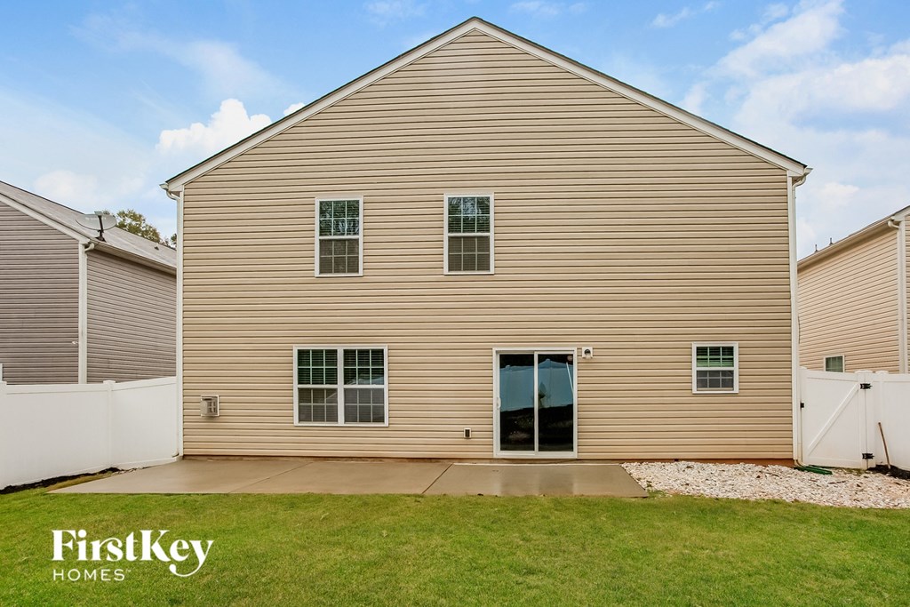 backyard and side view of a house with a driveway and grass