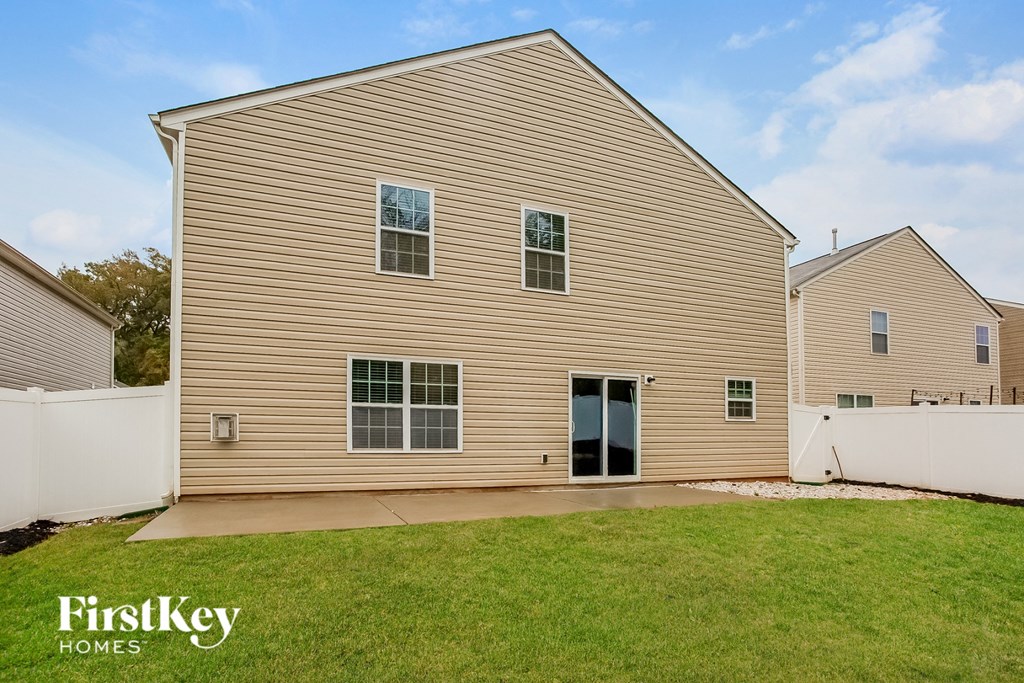 the backyard of a house with a yard and a sidewalk