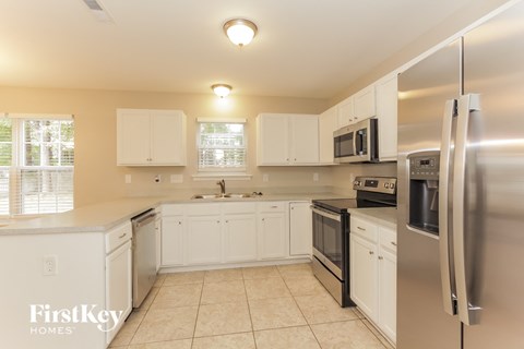 a kitchen with white cabinets and stainless steel appliances