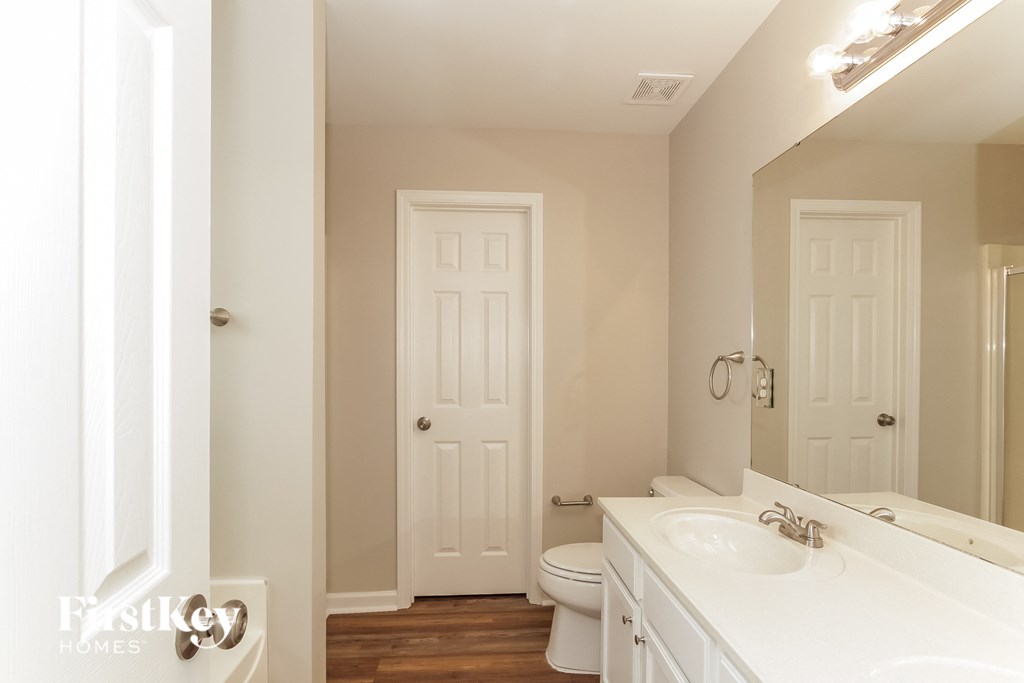 a bathroom with a toilet and a sink and a mirror