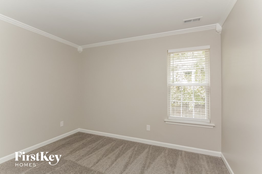 a bedroom with a carpeted floor and a window