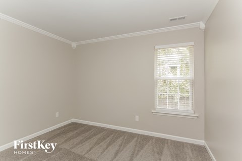 a bedroom with a carpeted floor and a window