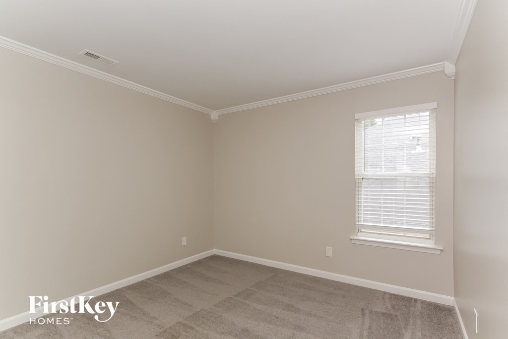 a empty room with a window and white walls