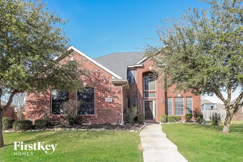 A brick house with a white door and windows.