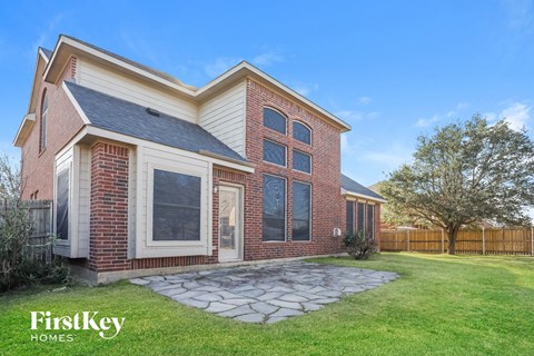 A brick house with a stone walkway in front.