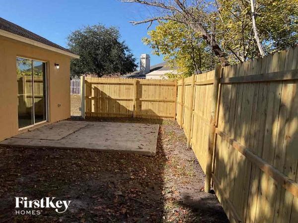 a backyard with a wooden fence and a patio