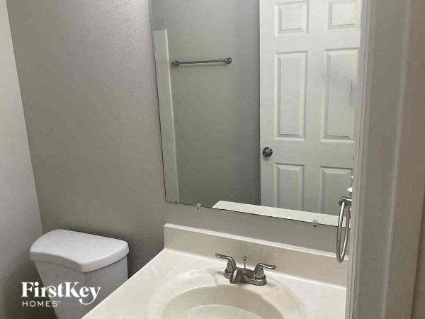 a bathroom with a toilet and a sink and a mirror