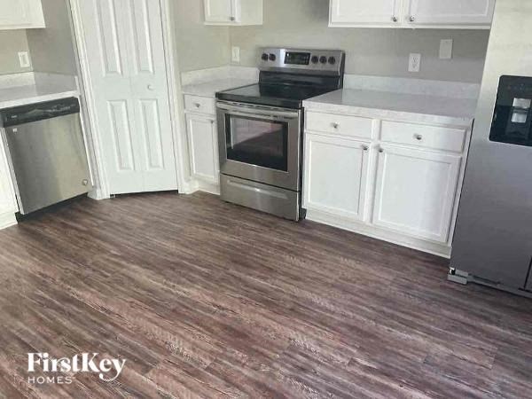 a kitchen with a stove and white cabinets
