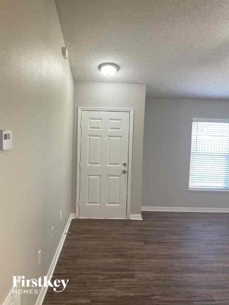 an empty room with a white door and wood floor
