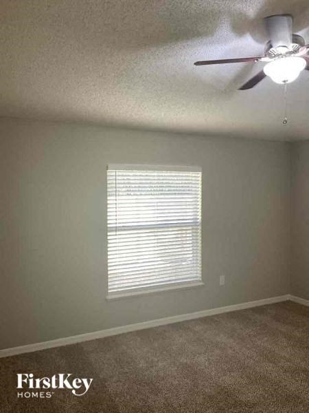 a living room with a ceiling fan and a window