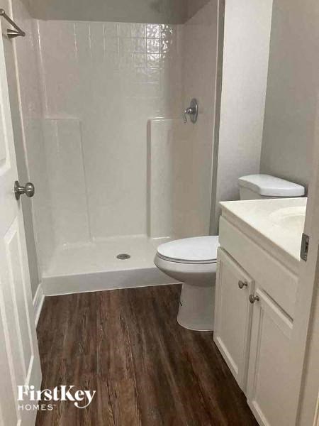 a white bathroom with a toilet and a shower