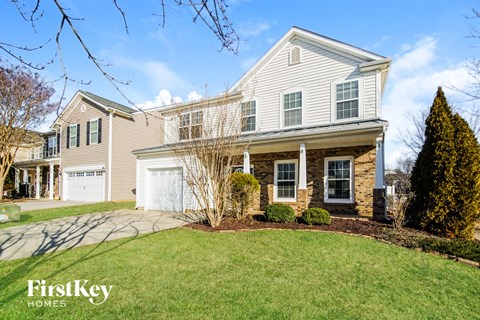 a house with a driveway and a lawn in front of it