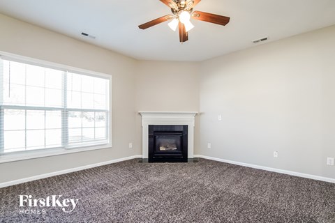 a living room with a fireplace and a ceiling fan