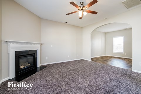 a living room with a fireplace and a ceiling fan