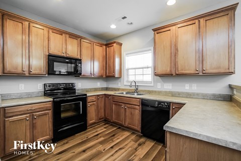 a kitchen with wooden cabinets and black appliances