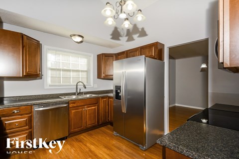 A kitchen with wooden cabinets and a stainless steel refrigerator.