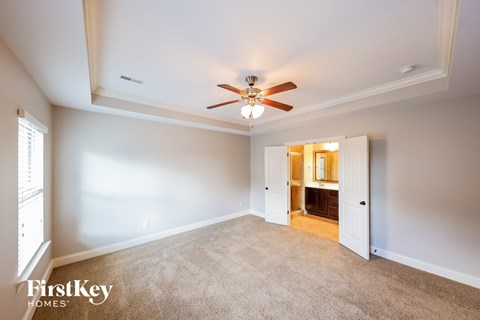 a living room with carpet and a ceiling fan