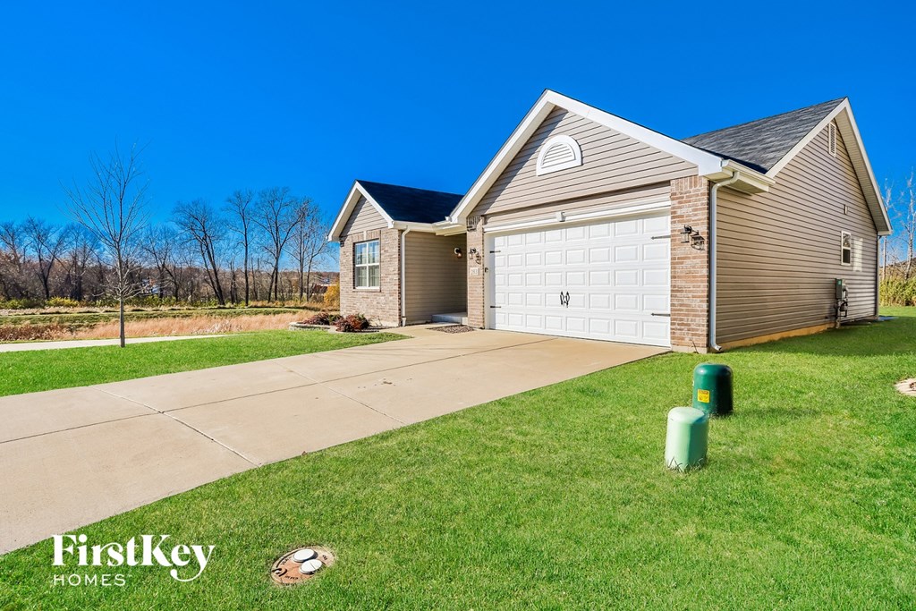 the front of a house with a driveway and a garage door