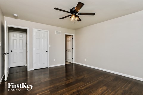 a living room with wood floors and a ceiling fan