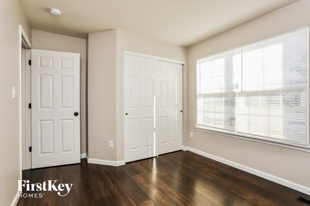 the living room of a home with white doors and a large window