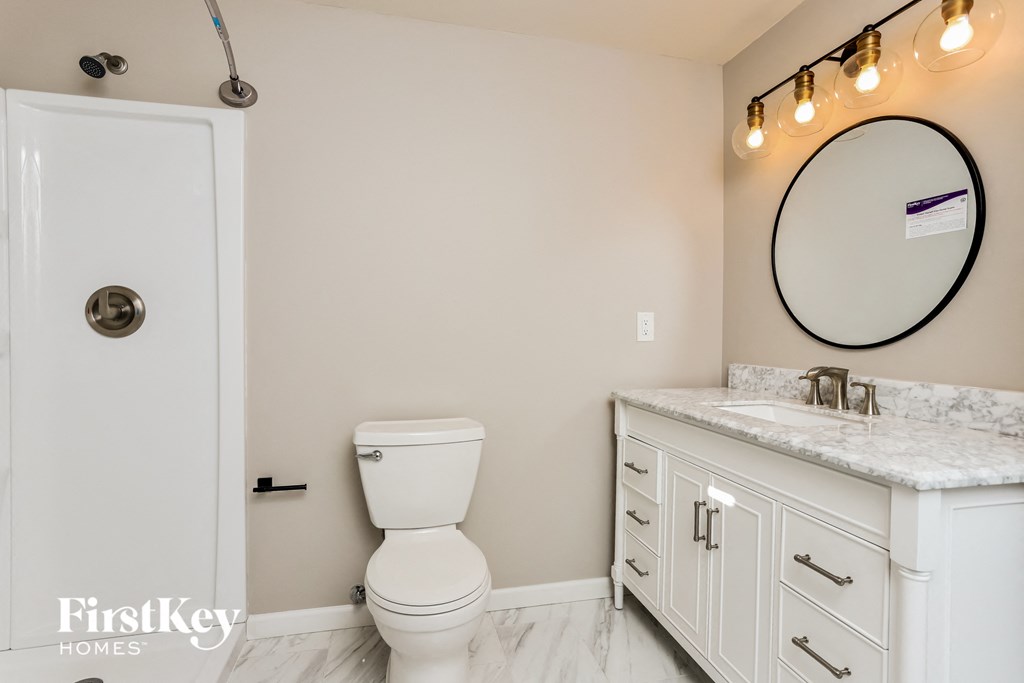 a bathroom with a toilet and a sink and a mirror