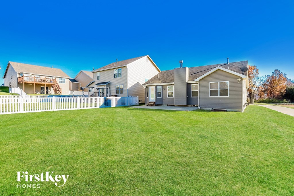 the backyard of a house with a white fence
