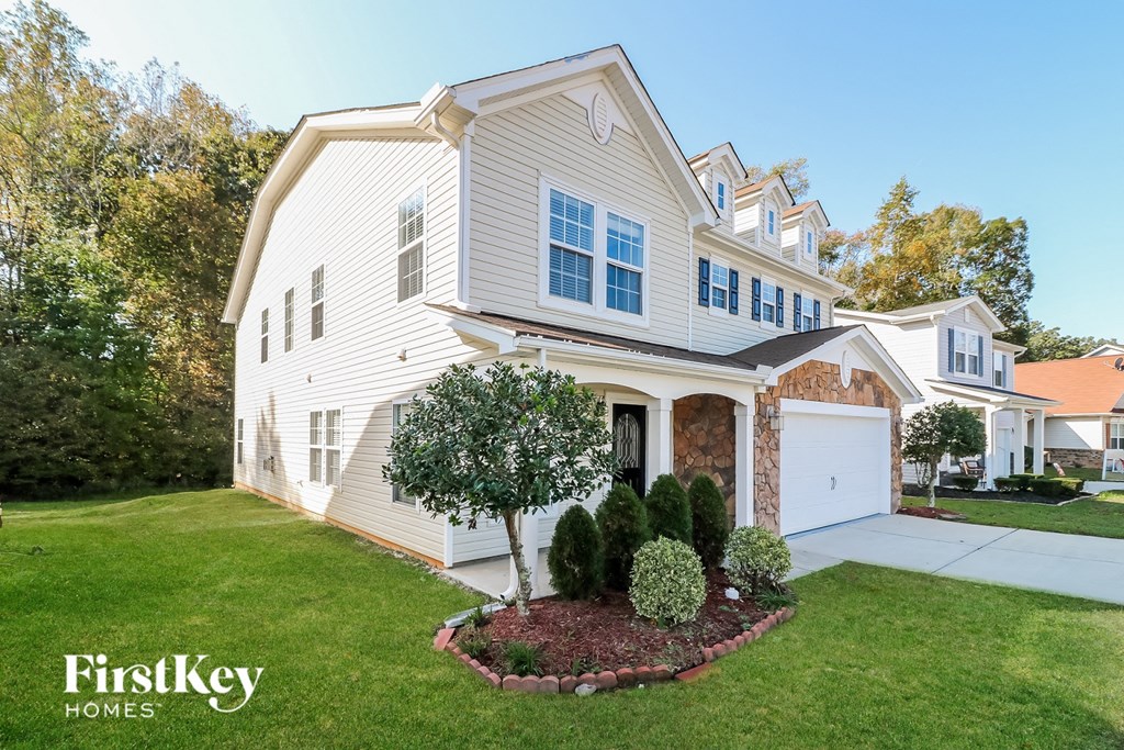 a white house with a lawn and a driveway